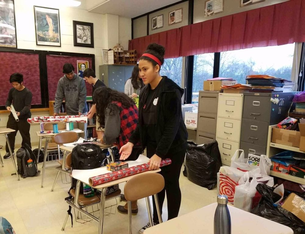 Conard Holiday Helpers wrap gifts in English teacher Cindy Vranich's classroom. Photo credit: CIndy Vranich