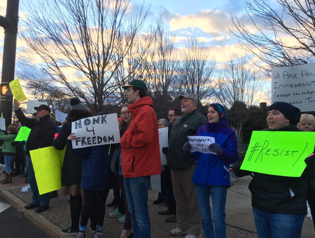 Protestors in front of the Veterans Memorial in West Hartford Center Sunday afternoon. The group gathered to protest the president's immigration ban. Photo credit: Ronni Newton