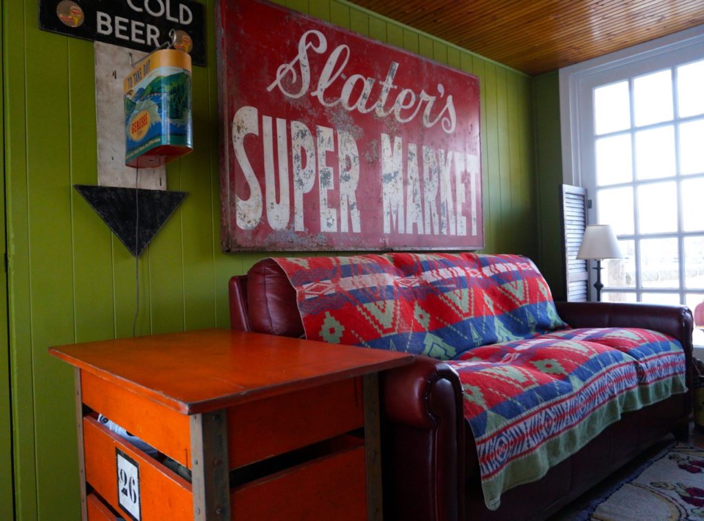 A Genesee Beer sign and vintage supermarket sign, along with a table made to look like a laundry cart in Jim Healy's breezeway. Photo credit: Ronni Newton