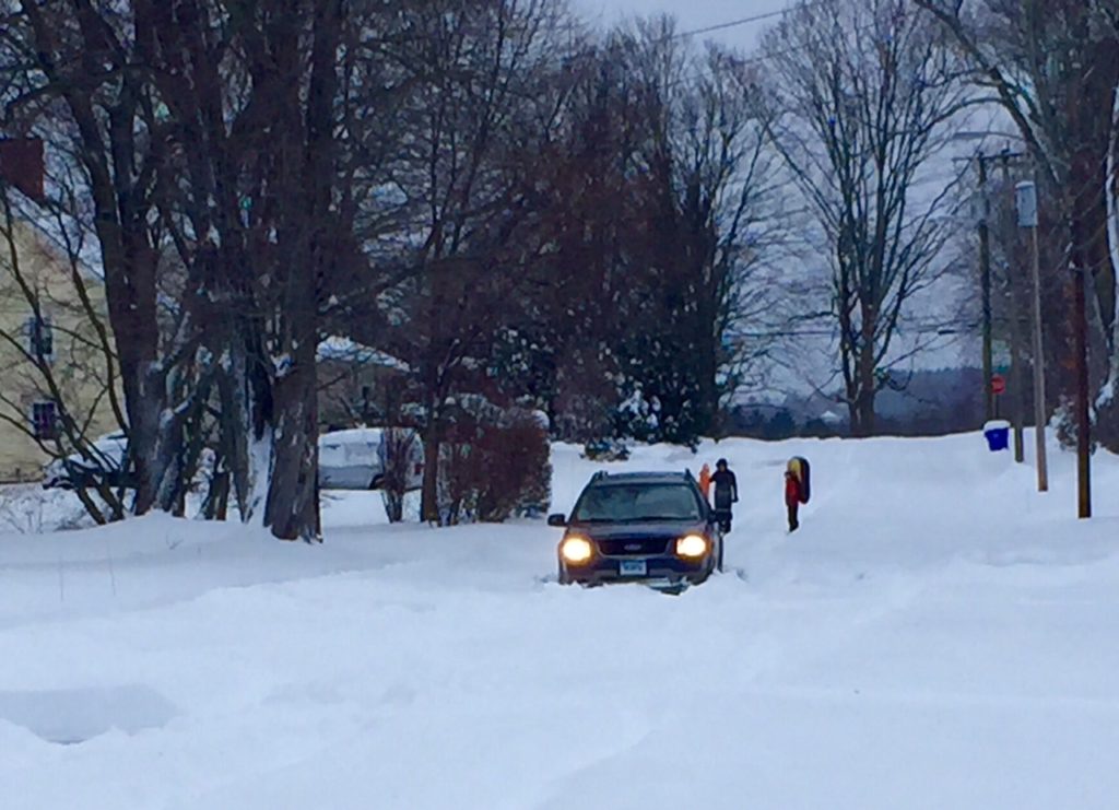 This car attempted to navigate an unplowed neighborhood street, and got stuck. Photo credit: Ronni Newton (taken on snowshoes)