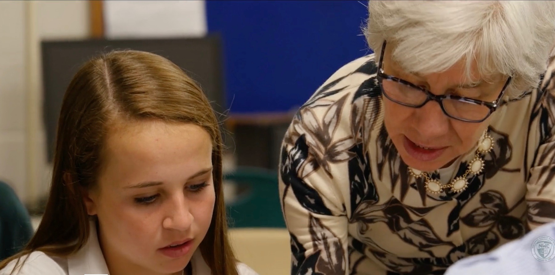 Northwest Catholic AP calculus teacher Deb Metzler (right) works with a student on a math equation